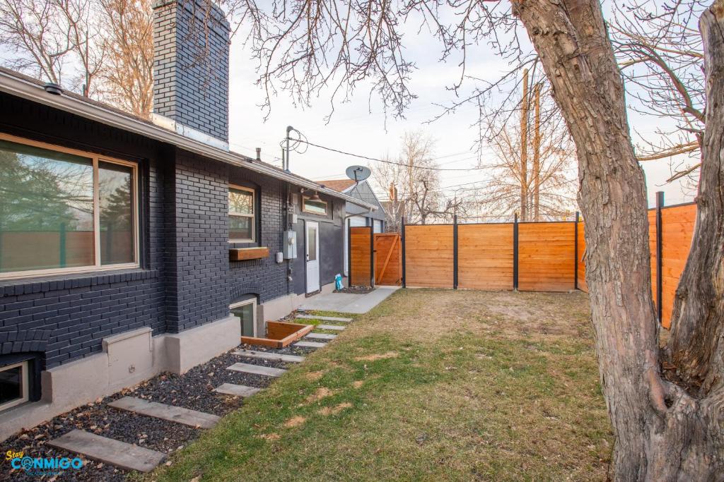 una casa de ladrillo negro con un árbol al lado en Parkway, en South Salt Lake