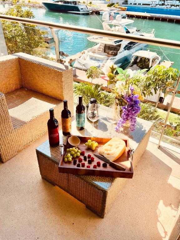a tray of cheese and wine on a table on a balcony at Marina Corazón Sea View - Condo Puerto Cancún in Cancún