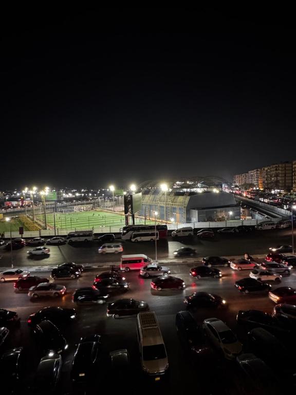 un estacionamiento lleno de coches por la noche con luces en Comfy 3-Bedrooms duplex Furnished Apartment in Cairo Sheraton airport, en El Cairo
