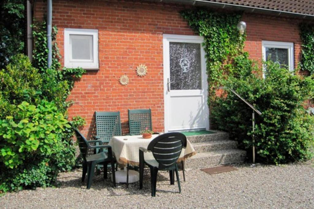un tavolo e delle sedie davanti a una casa di Ferienhof Ralf Becker Nr1 a Westfehmarn