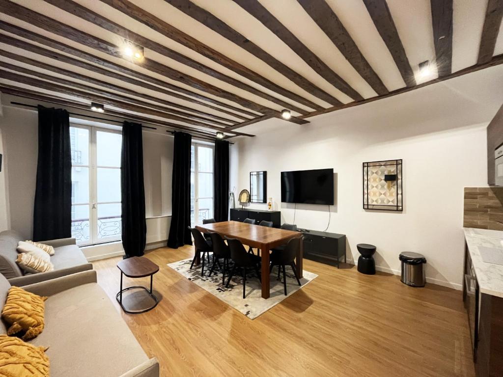 un salon avec une table et un canapé dans l'établissement Urban Flat 108 - Stunning 4 BDR Flat in Paris, à Paris