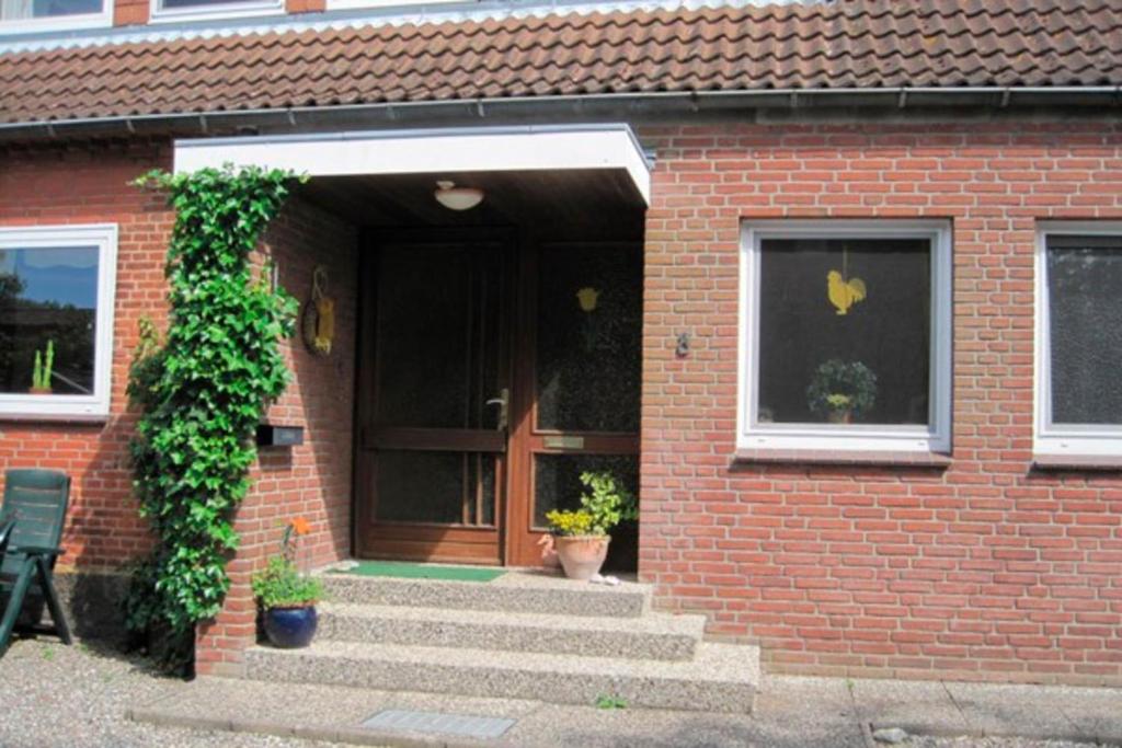 a brick house with stairs leading to a door at Ferienhof Ralf Becker Nr5 in Westfehmarn