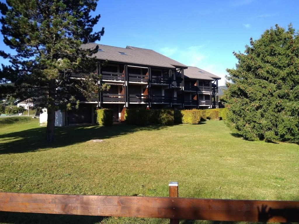 un grand immeuble avec une grande cour dans l'établissement Charmant studio à Autrans, proche pistes et village, balcon sud, parking privé, accepte animaux - FR-1-737-33, à Autrans