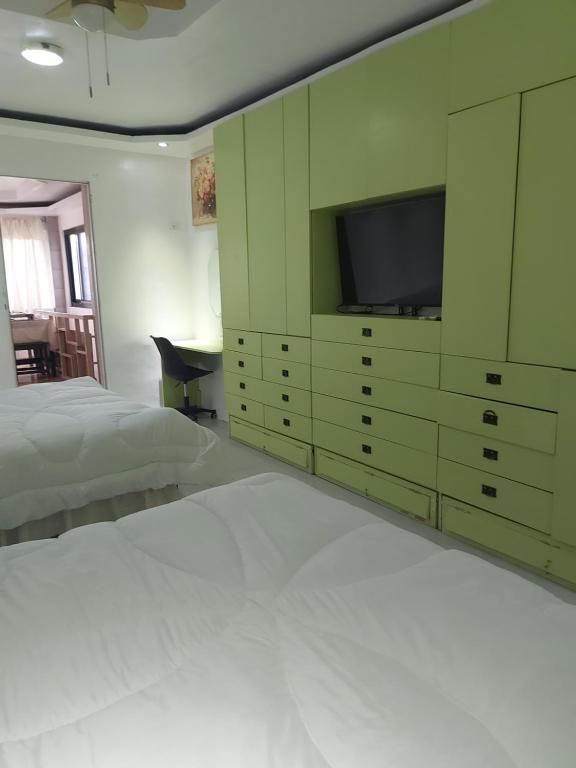 a bedroom with a bed and a flat screen tv at Room Calapan in Camilmil