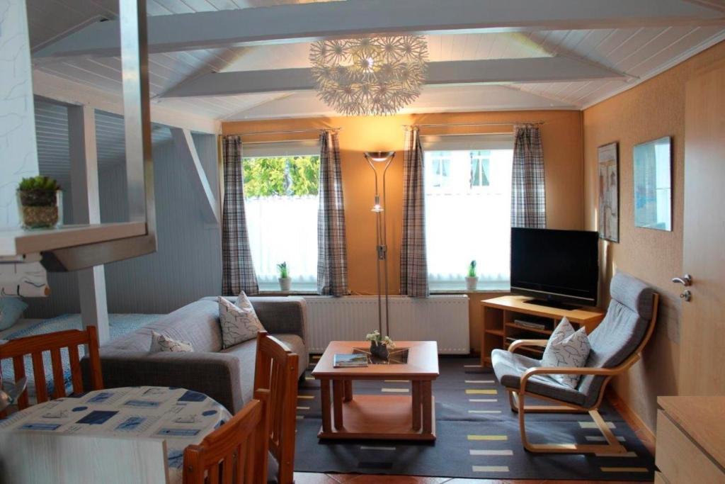 un soggiorno con un divano e una TV di Ferienwohnung Carstensen Nr1 a Fehmarn