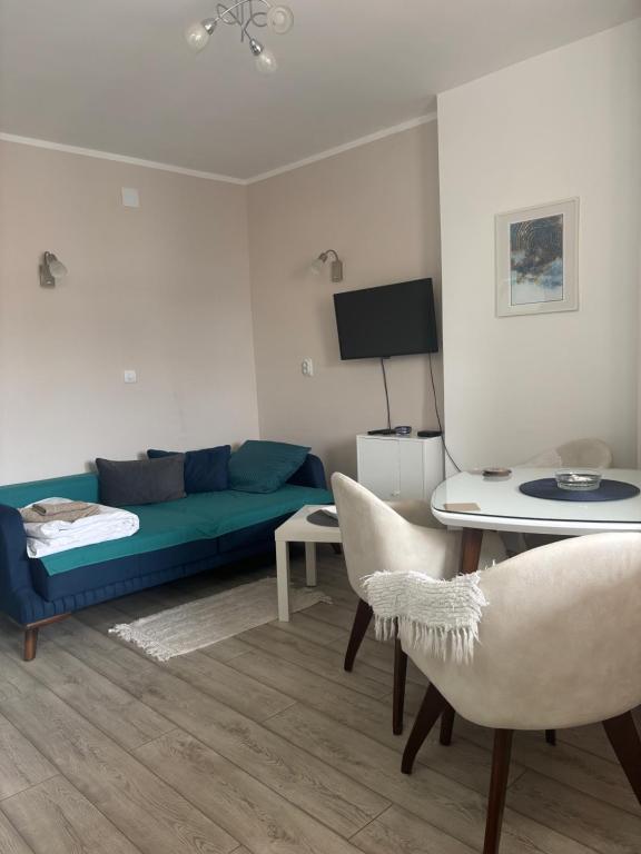 a living room with a couch and a table and chairs at Red Square Apartment in Pirot