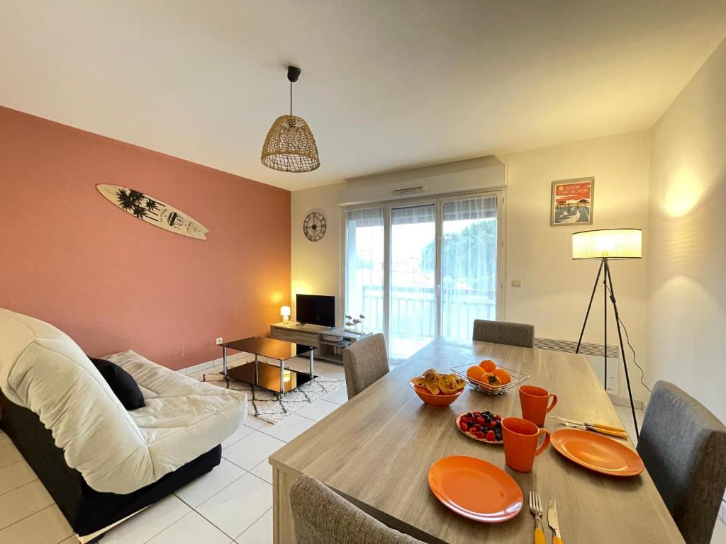 un salon avec une table et une salle à manger dans l'établissement Confort & Balcon,Cœur de Biscarrosse !, à Biscarrosse