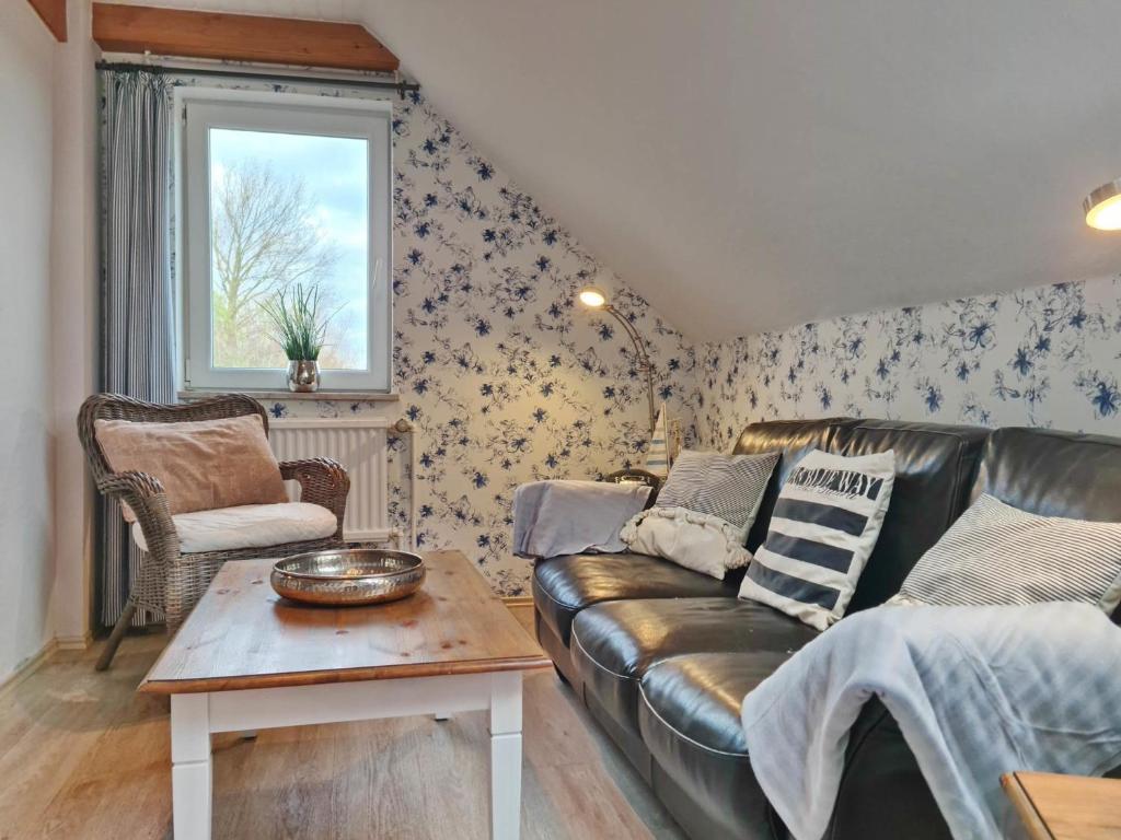 a living room with a leather couch and a table at MeerBlüte in Vadersdorf