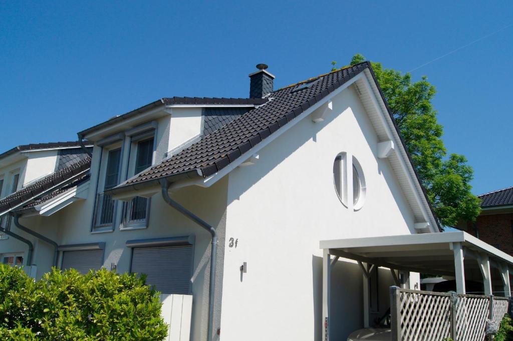 a white house with a black roof at Feriendoppelhaushälfte Böttcher in Meeschendorf