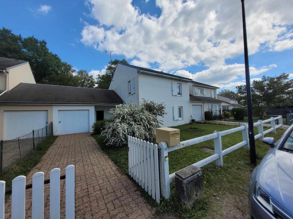 a white fence in front of a white house at Maison, 5 Chambres équipées, tout confort , fibre in Ouzouer-sur-Loire