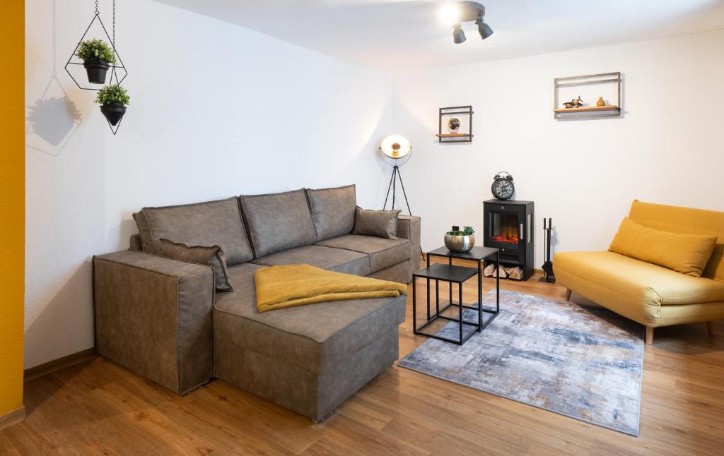 a living room with a couch and a chair at Altbauoase Fulda - ruhig, zentral, Terrasse, Bahnhof 400m - in Fulda
