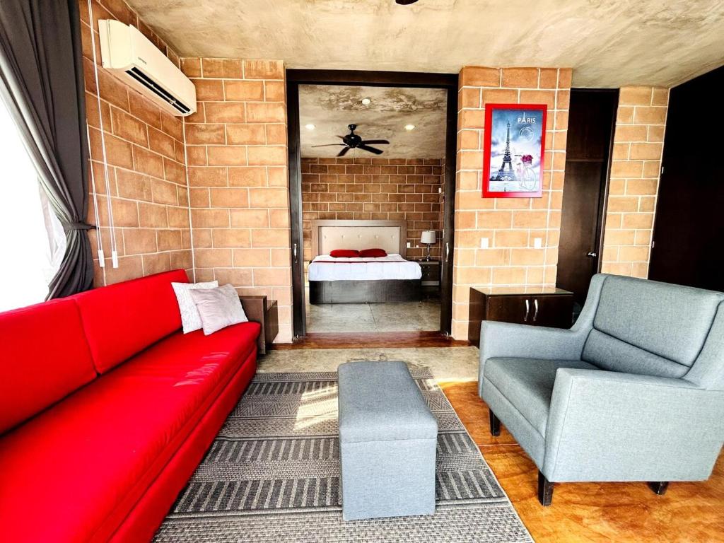 a living room with a red couch and a bed at Vistas Increíbles frente al mar by G P S rentas in Mazatlán