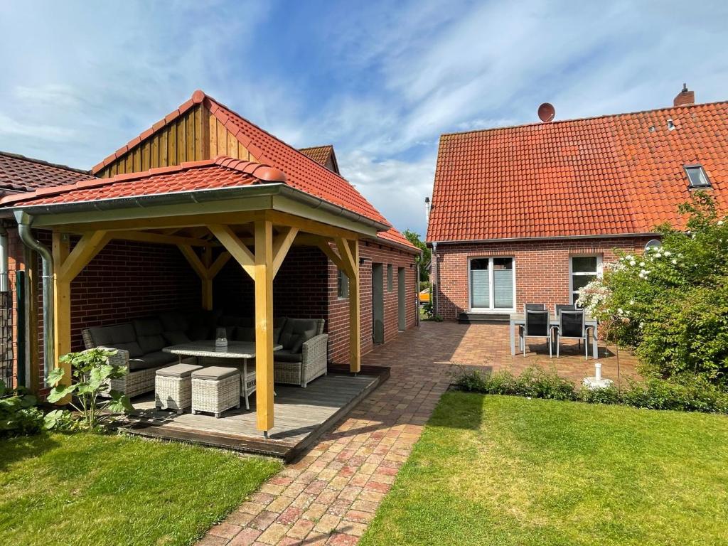 a pavilion with a table and chairs on a patio at Haus am Stadtpark in Burg auf Fehmarn
