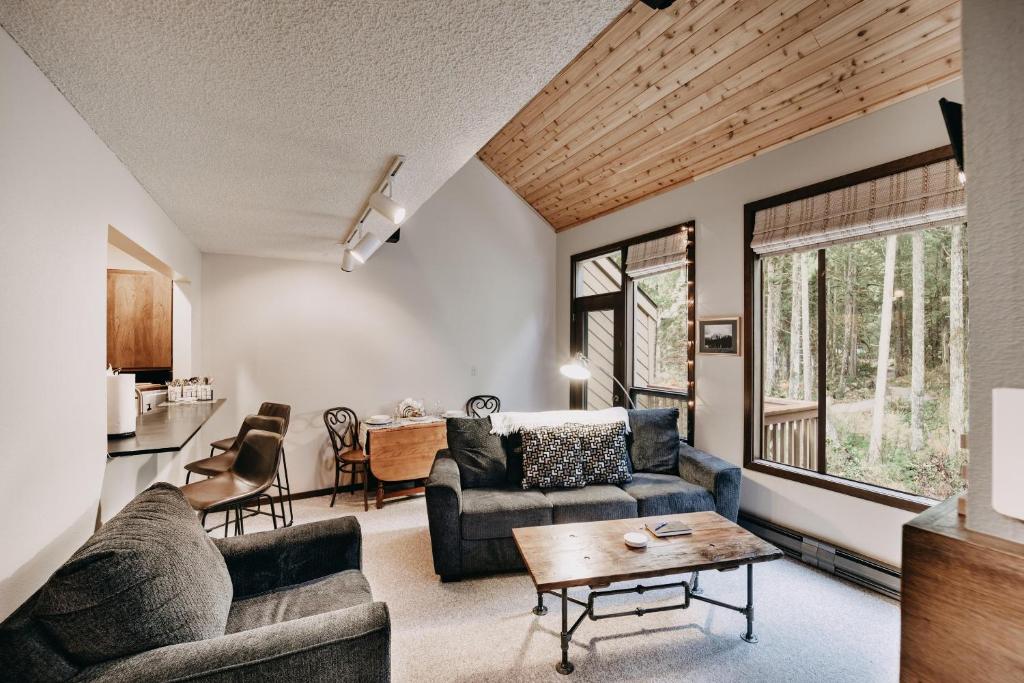 ein Wohnzimmer mit Sofa und Tisch in der Unterkunft Snowater Condo #14 - Blissful Relaxation! in Glacier