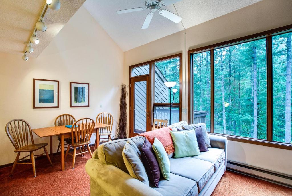 ein Wohnzimmer mit Sofa und Tisch in der Unterkunft Snowater Condo #85 - Fireplace - 2-Story Sleeps 4 in Glacier