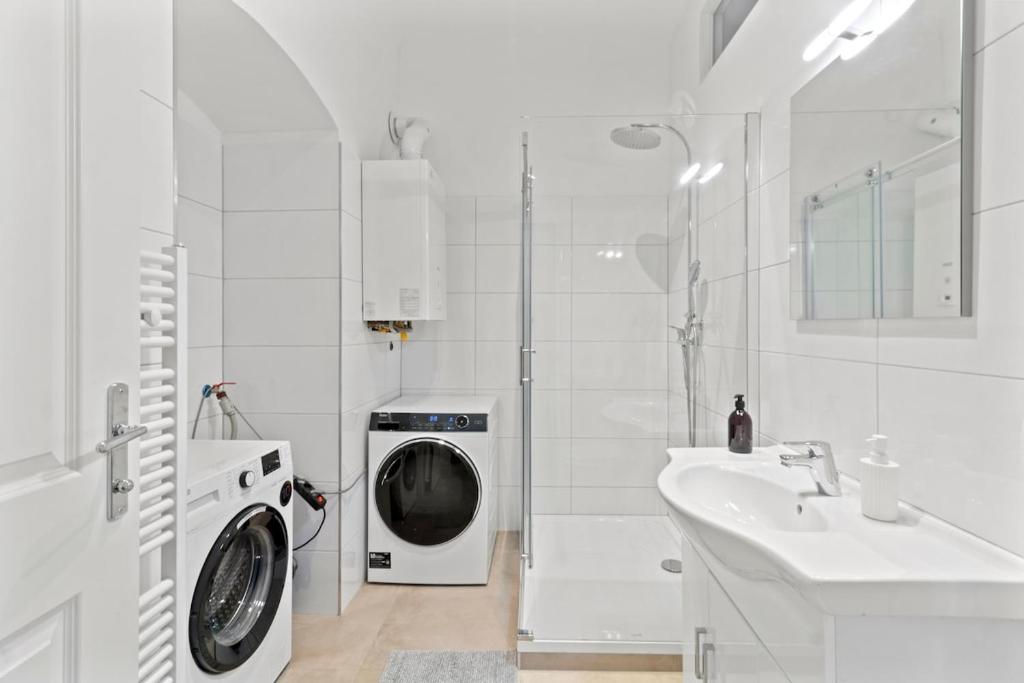 a white bathroom with a washing machine and a sink at Fast Wifi I 4 min to U3 Zipperer Straße in Vienna