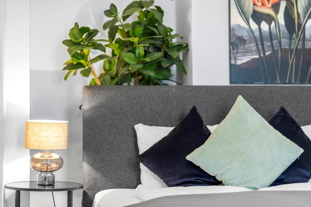 a couch with pillows and a lamp on a table at Fast Wifi I 4 min to U3 Zipperer Straße in Vienna