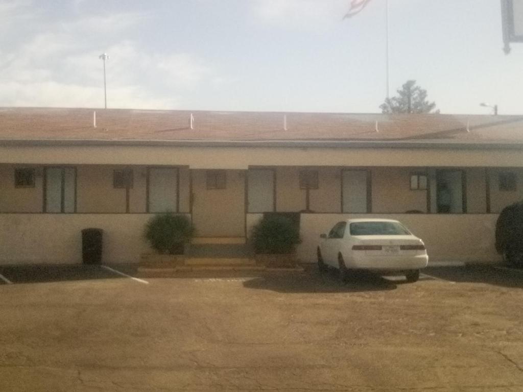Un coche blanco aparcado delante de un edificio en BV Motel LLC, en Searchlight