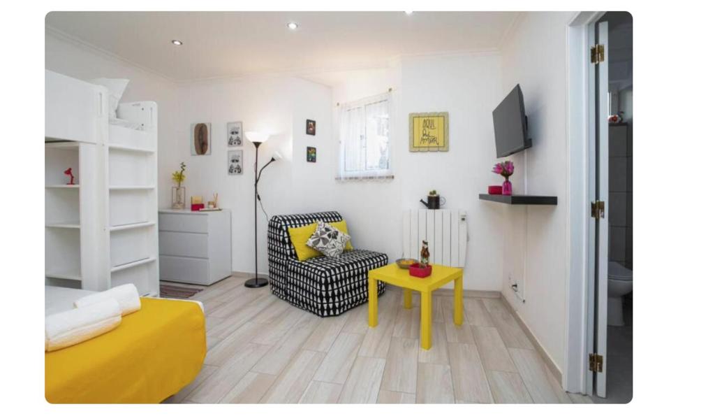 a living room with a yellow table and a chair at BeGuest Casetta Cleo in Páteo