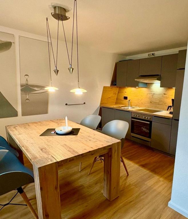a kitchen with a wooden table and chairs in a room at Ferienwohnung Süd in Fehmarn
