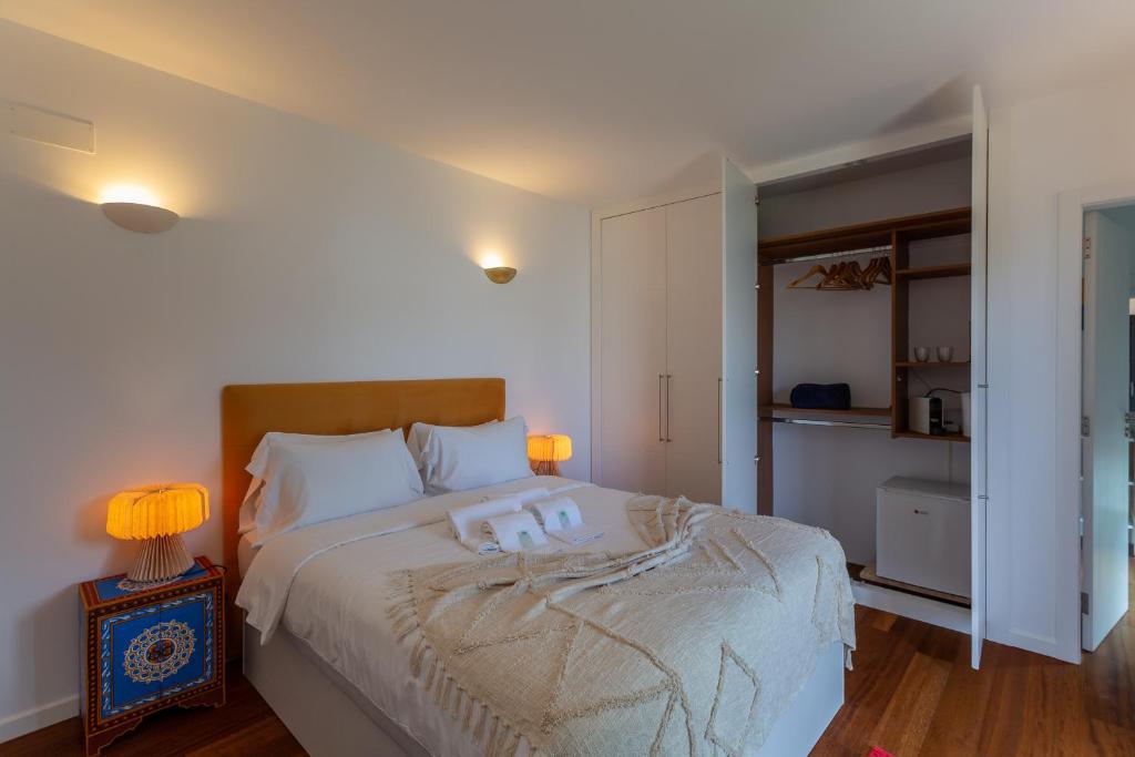 a bedroom with a bed with two candles on it at Penedo Escape Sea Suites in Colares