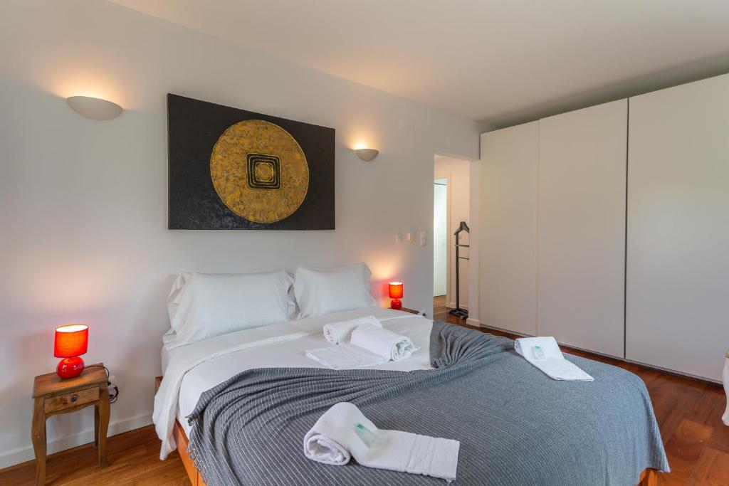 a bedroom with a bed with two towels on it at Penedo Escape Sea Suites in Colares