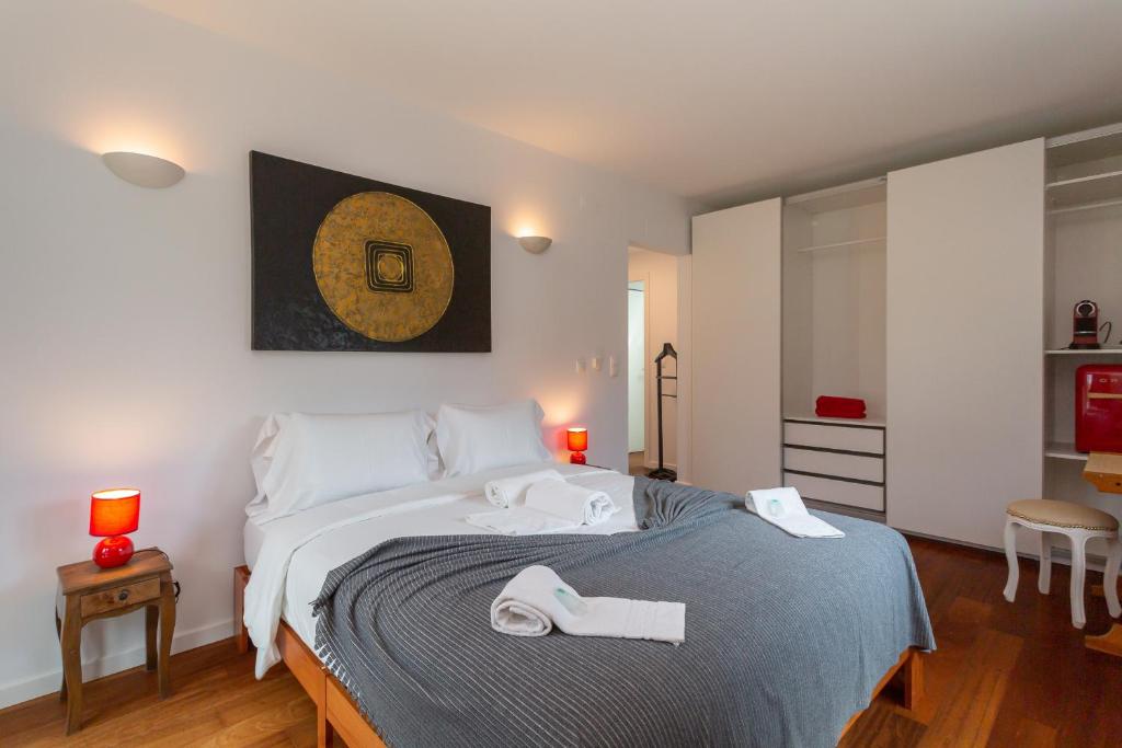 a bedroom with a large bed with two towels on it at Penedo Escape Sea Suites in Colares