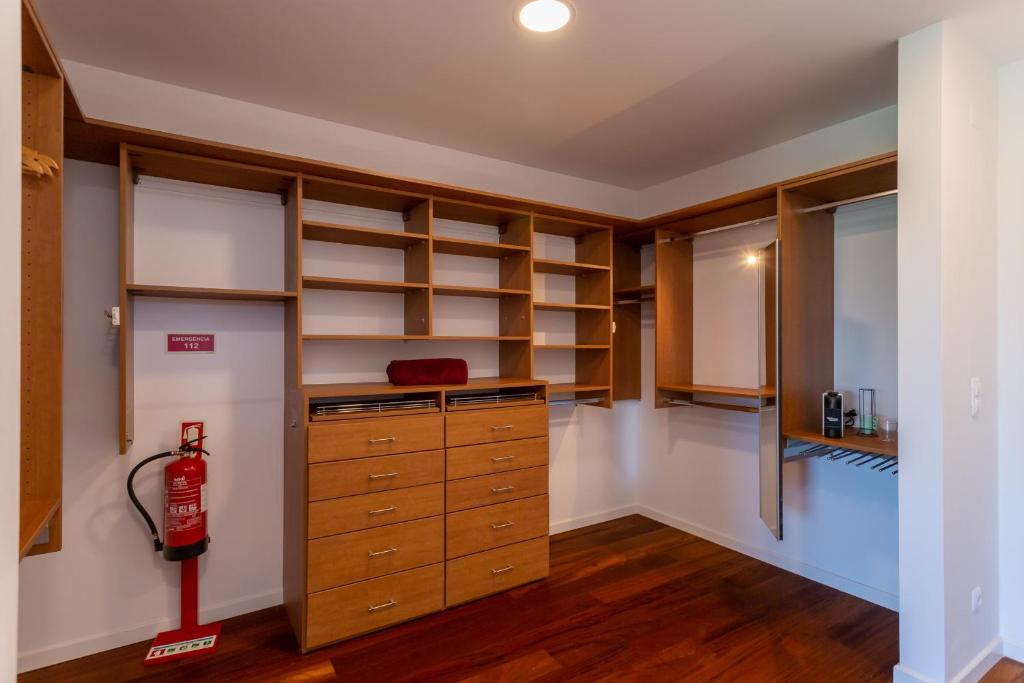 a walk in closet with wooden shelves and a fire extinguisher at Penedo Escape Sea Suites in Colares
