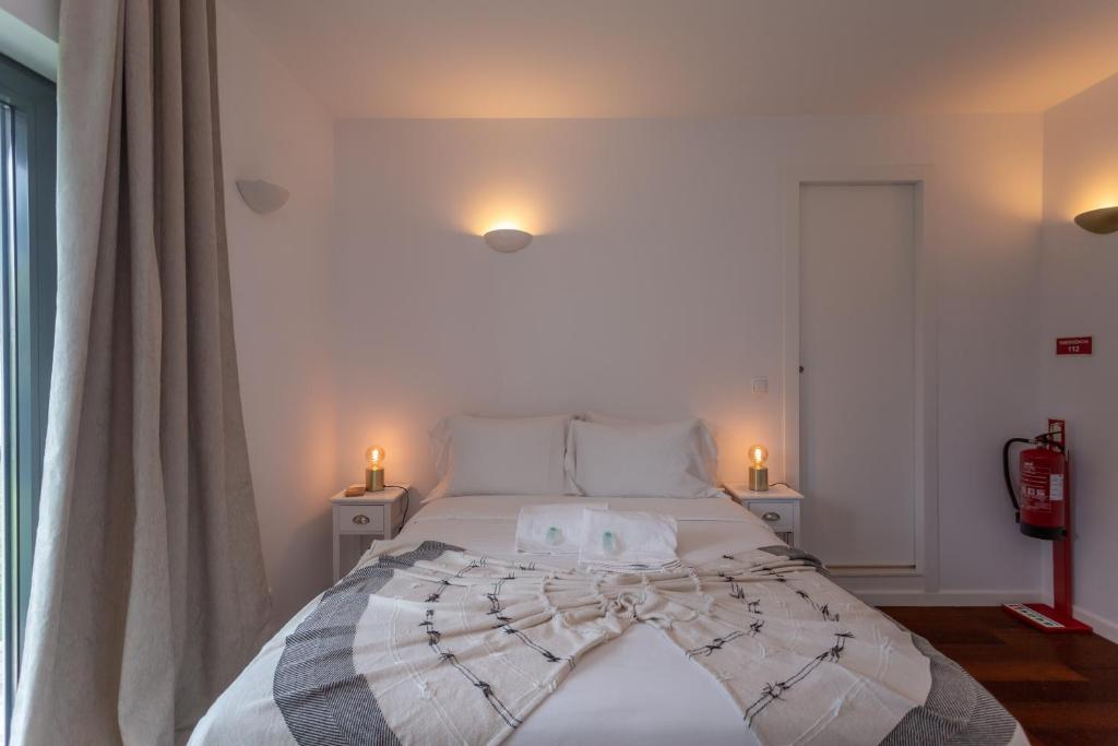 a bedroom with a bed with two candles on it at Penedo Escape Sea Suites in Colares