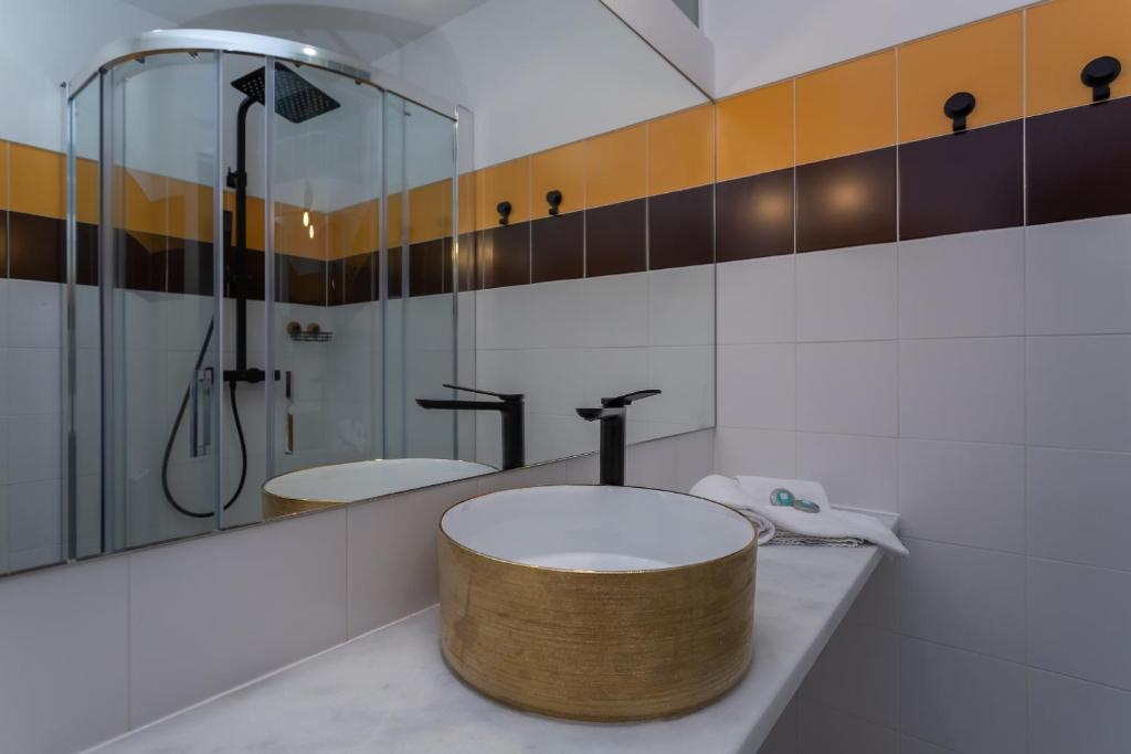a bathroom with a round sink and a shower at Penedo Escape Sea Suites in Colares