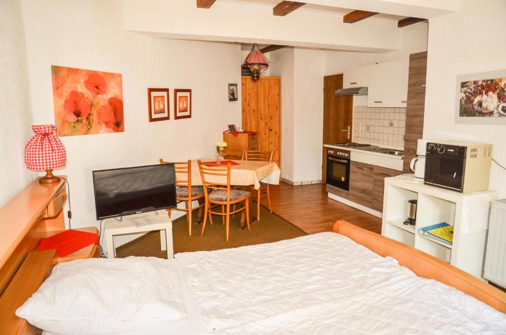 a room with a bed and a kitchen with a table at Ferienhof Frohne - Zum wilden Eber in Merzen