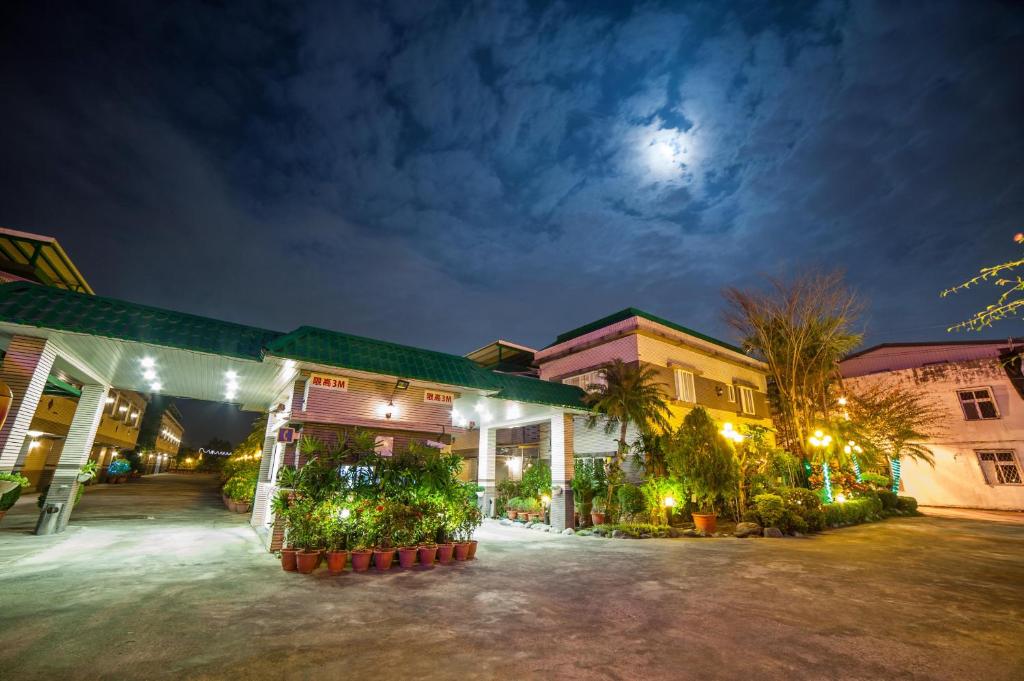 un grupo de edificios de noche con la luna en el cielo en Mesasa Garden Motel, en Jian