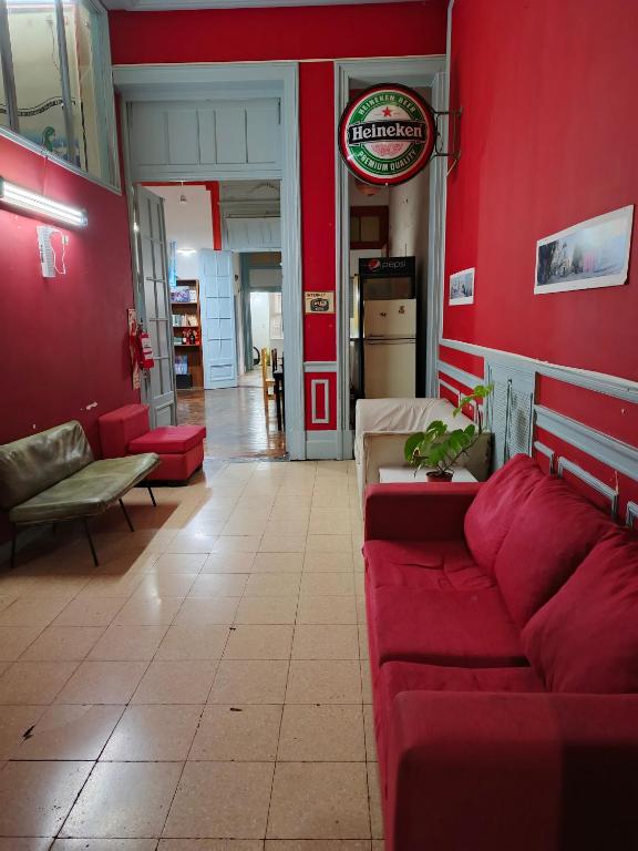 a living room with red walls and red couches at Hostel Downtown Las Morenas in Buenos Aires
