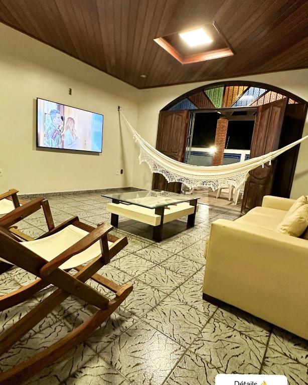a living room with a hammock and a couch at SOLAR DA BRAN Mosqueiro - Pará in Belém