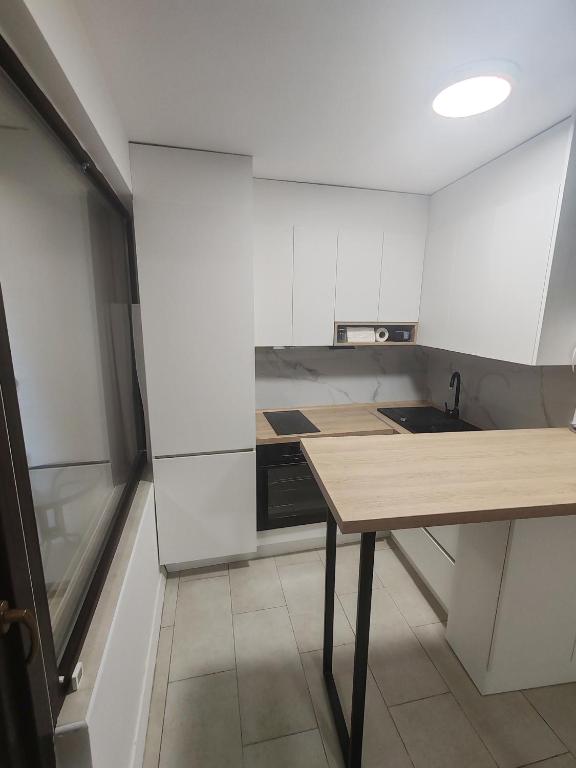 Una cocina con una mesa de madera y un fregadero. en Maksimilijan, en Ohrid