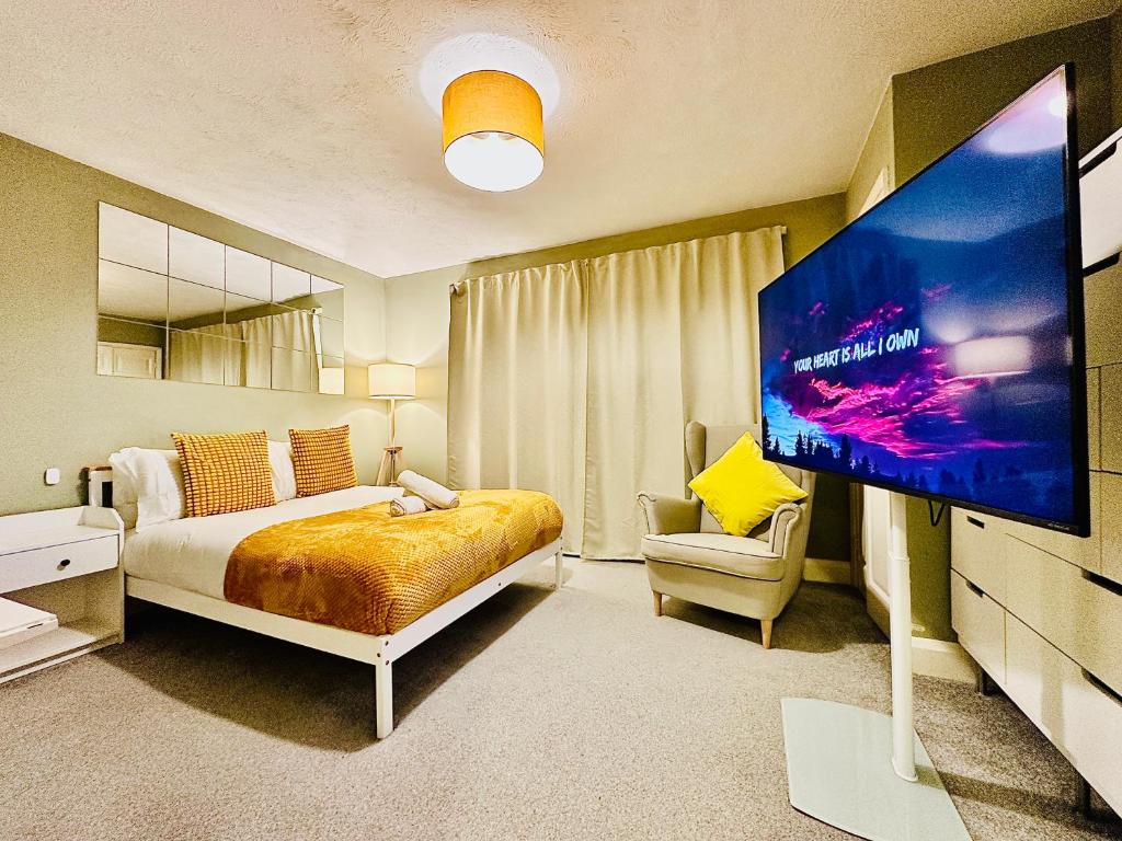 a bedroom with a bed and a flat screen tv at Opulent Marriott in London