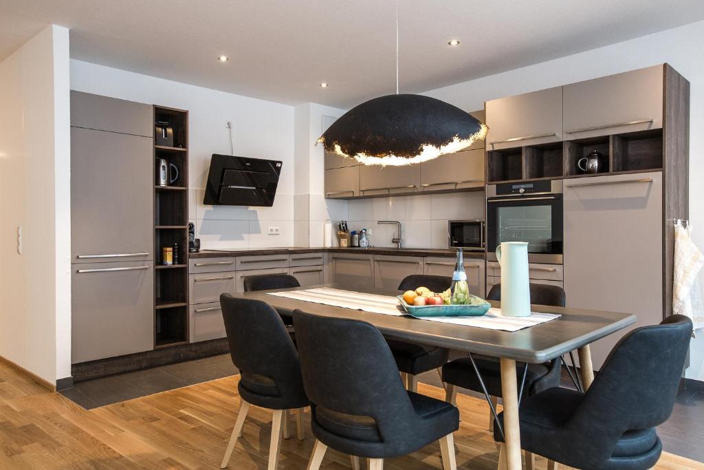 eine Küche und ein Esszimmer mit Tisch und Stühlen in der Unterkunft Ferienwohnung "Pfänder" in Friedrichshafen