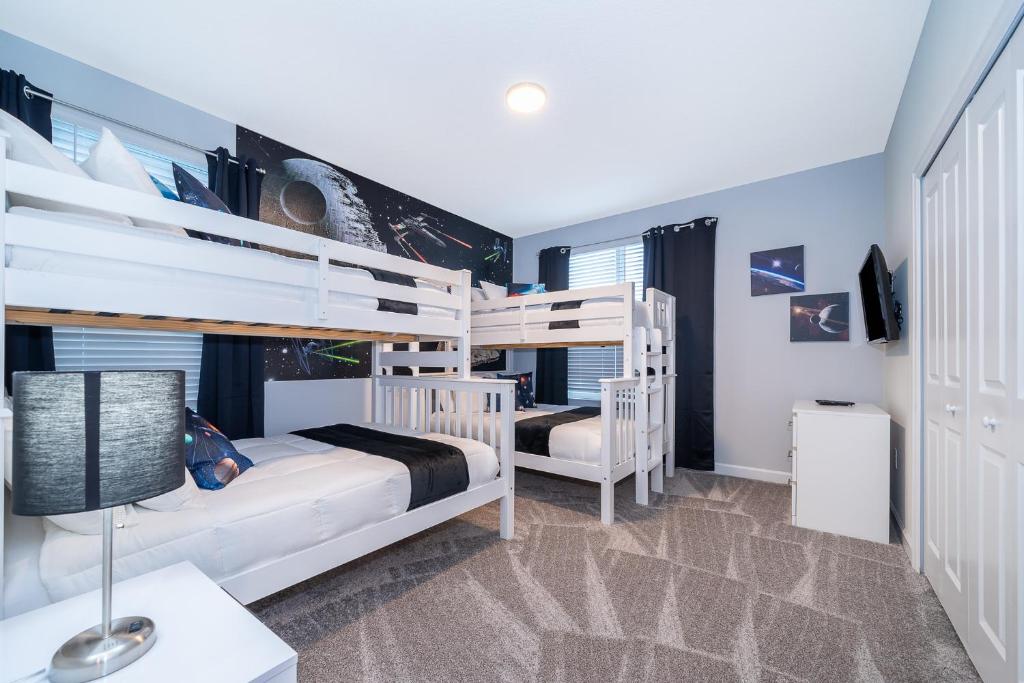 a bedroom with two bunk beds and a desk at Fabulous Villas 5 minutes away from Disney! in Kissimmee