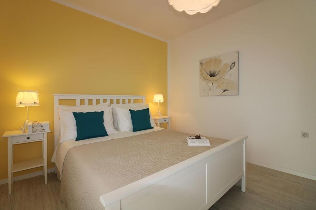 sypialnia z dużym łóżkiem z niebieskimi poduszkami w obiekcie Ferienwohnung Rosmarin Porec w Poreču