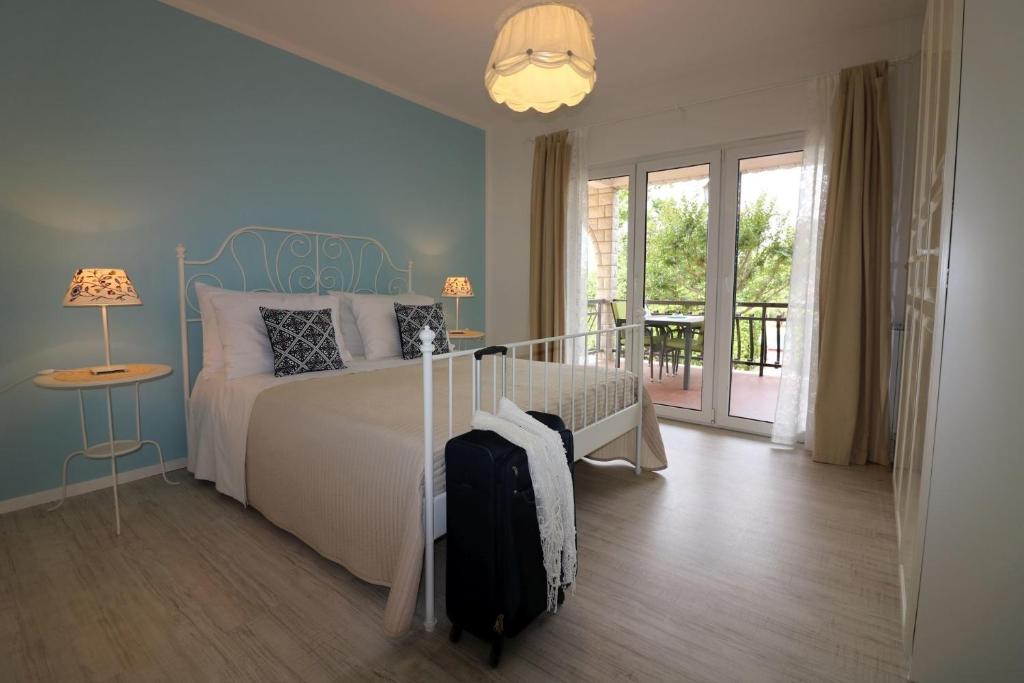 sypialnia z łóżkiem z walizką w obiekcie Ferienwohnung Rosmarin Porec w Poreču
