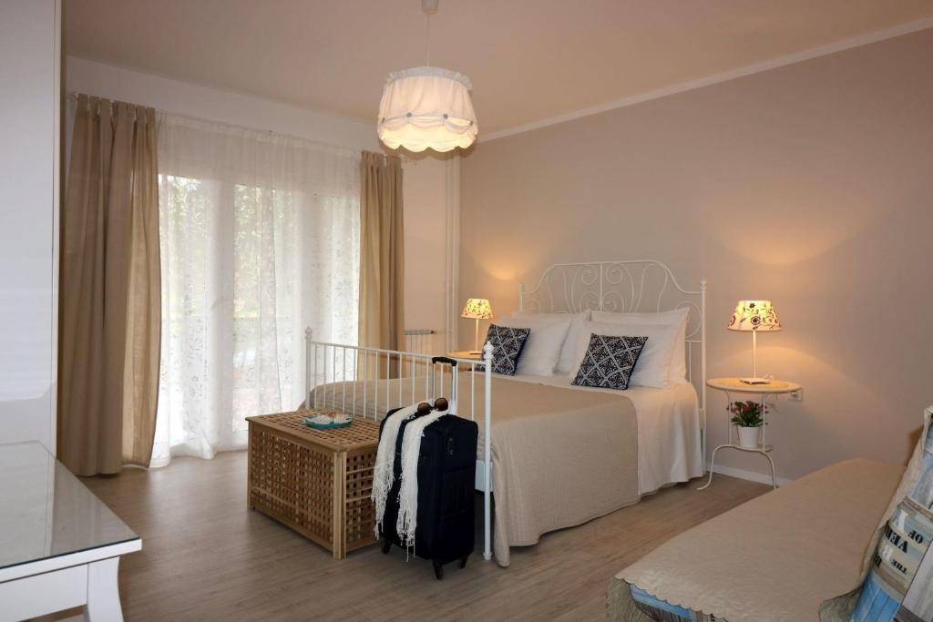 sypialnia z białym łóżkiem i dużym oknem w obiekcie Ferienwohnung Rosmarin Porec w Poreču