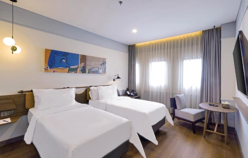 Postel nebo postele na pokoji v ubytování ARTOTEL Hub Simpang Temu Jakarta