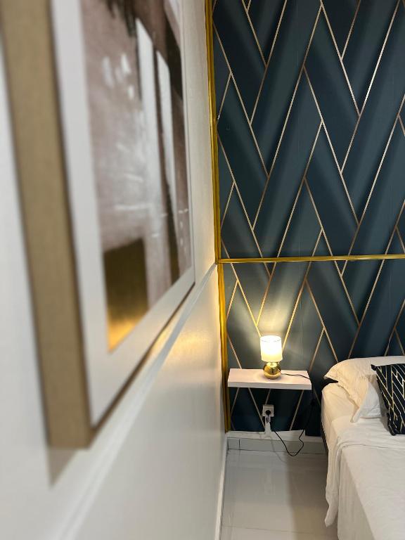 una camera da letto con una parete con accenti blu e oro di CYRUS Hôtel -Housse cœur de ville a Pointe-à-Pitre