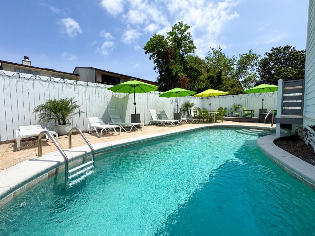 une piscine avec chaises et parasols sur un patio dans l'établissement Limearita- Beach house, private heated pool, à Destin
