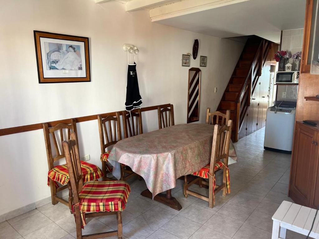 a dining room with a table and chairs and a kitchen at Departamento 4 Ambientes frente al mar - San Bernardo - Cochera - Parrilla in San Bernardo