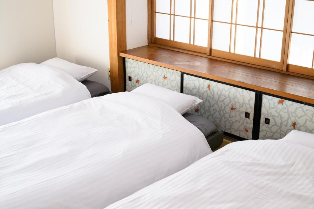 Postel nebo postele na pokoji v ubytování 玉造和暖 WaDan 島根県玉造温泉街に佇む和の趣あふれる古民家旅館 supported by COCOSTAY