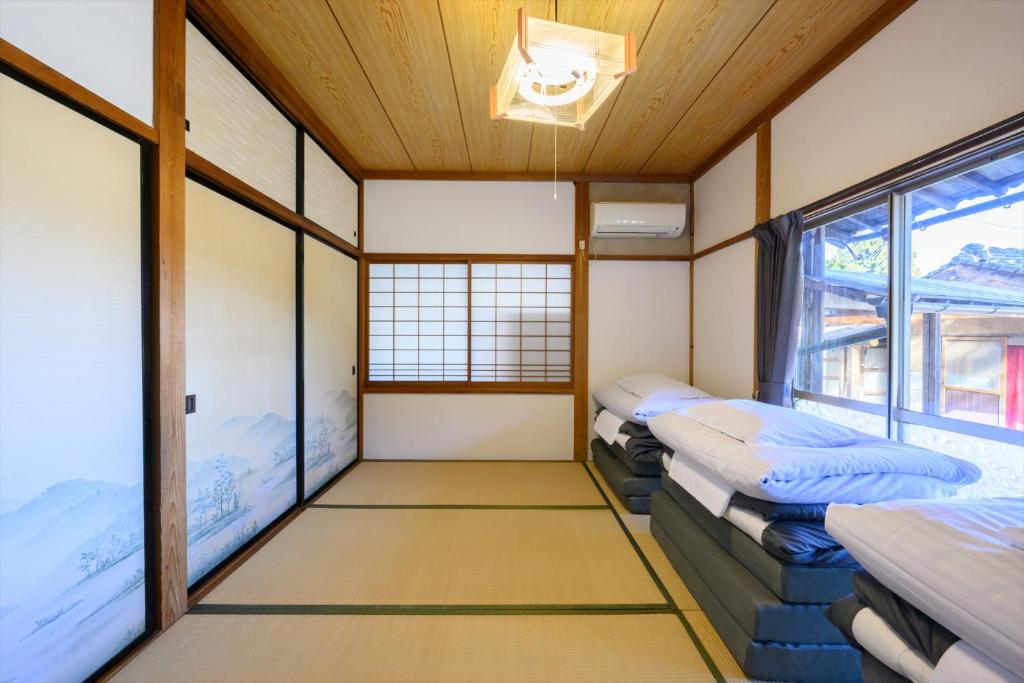 Postel nebo postele na pokoji v ubytování 玉造和暖 WaDan 島根県玉造温泉街に佇む和の趣あふれる古民家旅館 supported by COCOSTAY