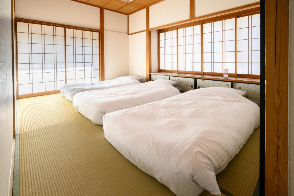 Postel nebo postele na pokoji v ubytování 玉造和暖 WaDan 島根県玉造温泉街に佇む和の趣あふれる古民家旅館 supported by COCOSTAY