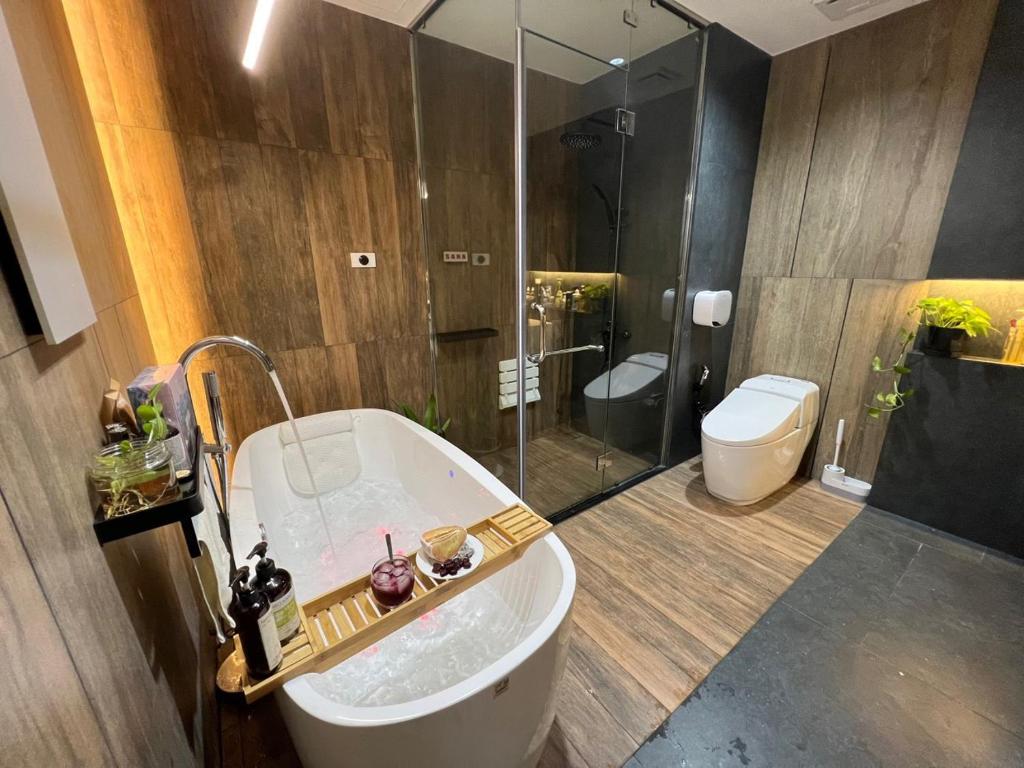 a bathroom with a tub and a shower and a toilet at SISI Căn hộ du lịch Huế in Ấp Hà Dồ