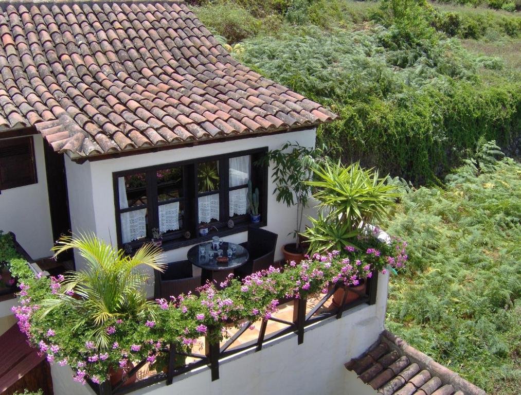 a balcony with flowers and plants on a house at Rustikale Ferienwohnung mit Balkon und Meerblick in Icod de los Vinos